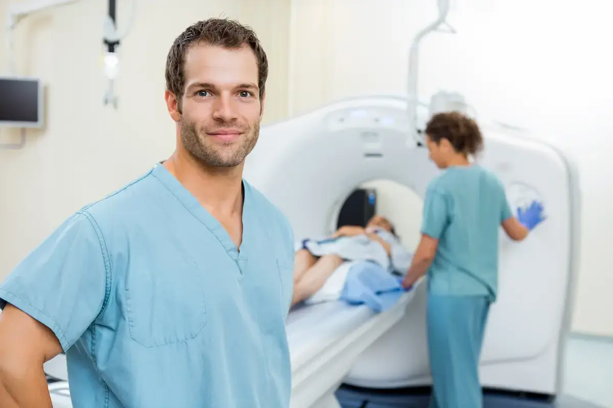Radiology tech standing in front of a MRI machine