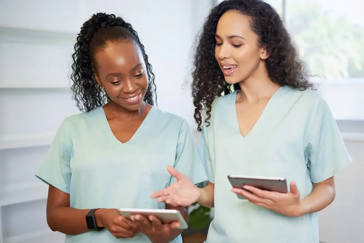 Two mammographers chatting over an ipad
