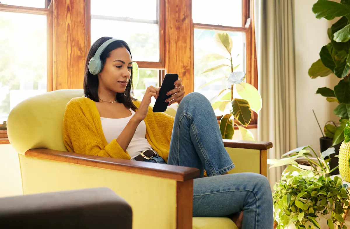 Woman lounging in a chair at home listening to the top rated nursing podcasts by healthcare professionals