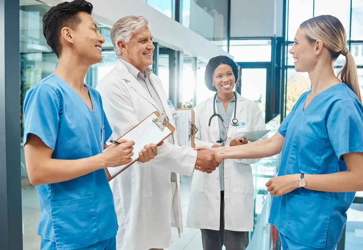 Contract LPNs having a conversation with physicians in a hospital lobby