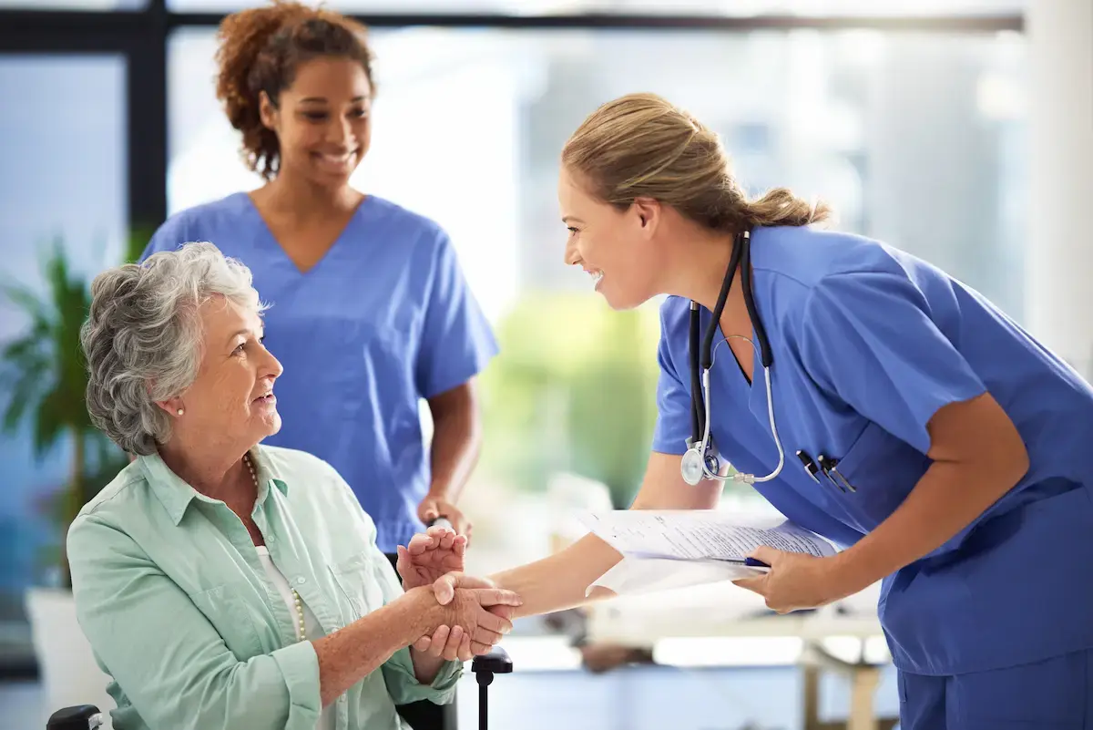 Medical assistant introducing themselves to a patient in a hospital lobby