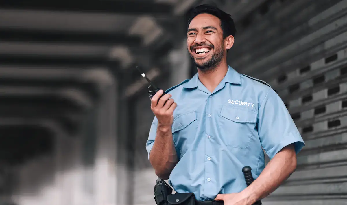 Hospital security guard smiling with a walkie-talkie