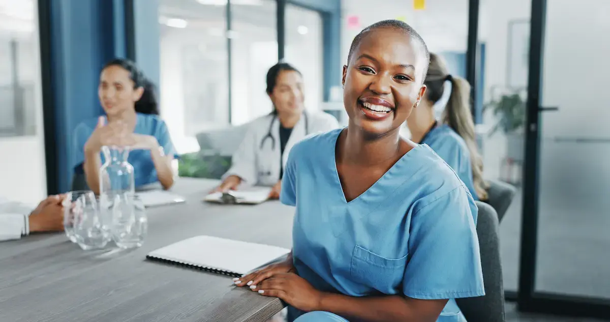 Ultrasound technologist smiling while sitting at a table with other techs