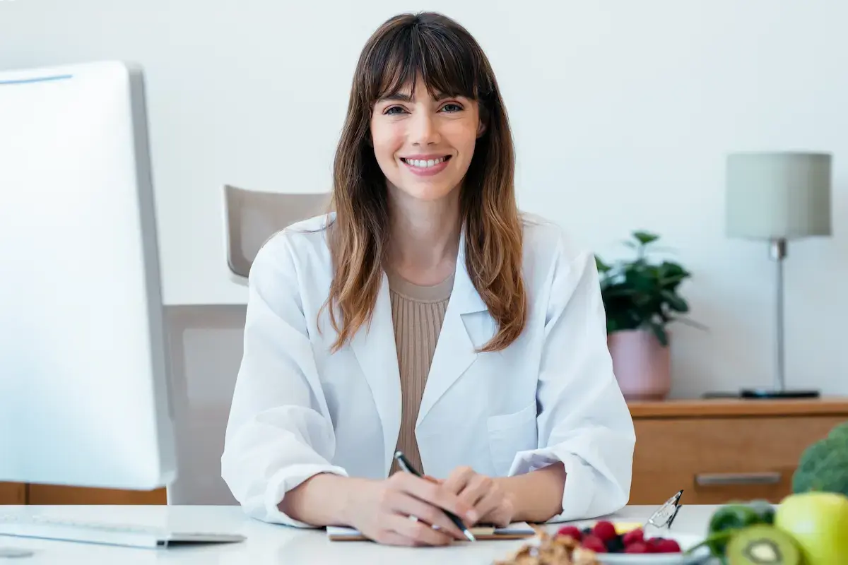 Registered dietician smiling at their desk