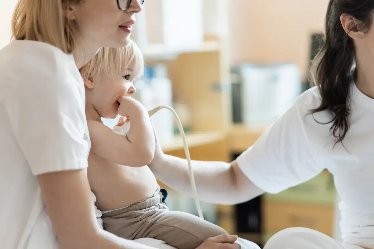 Echo tech checking out a small child's heart with ultrasound equipment