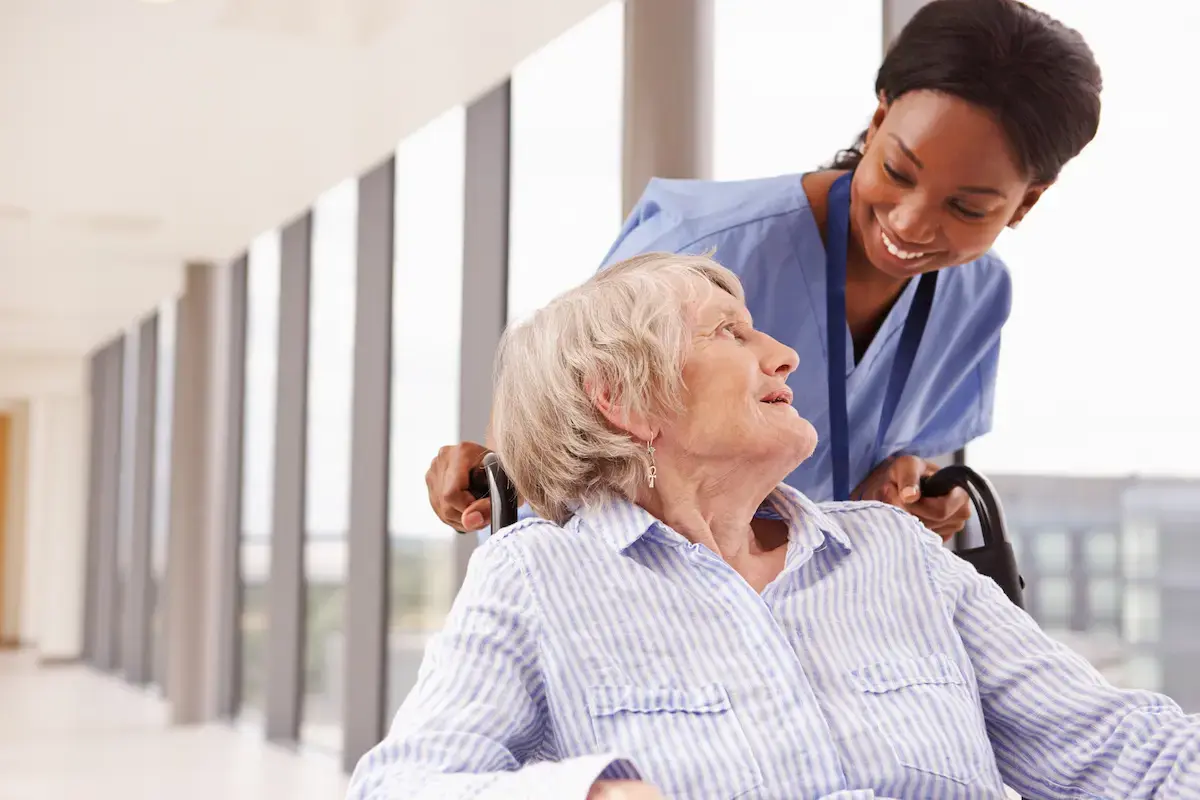 Radiation therapist helping a patient in a wheelchair get around a hospital