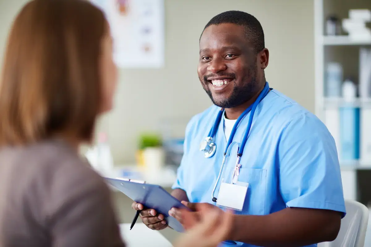 Direct hire nurse working at a clinic and smiling at a patient