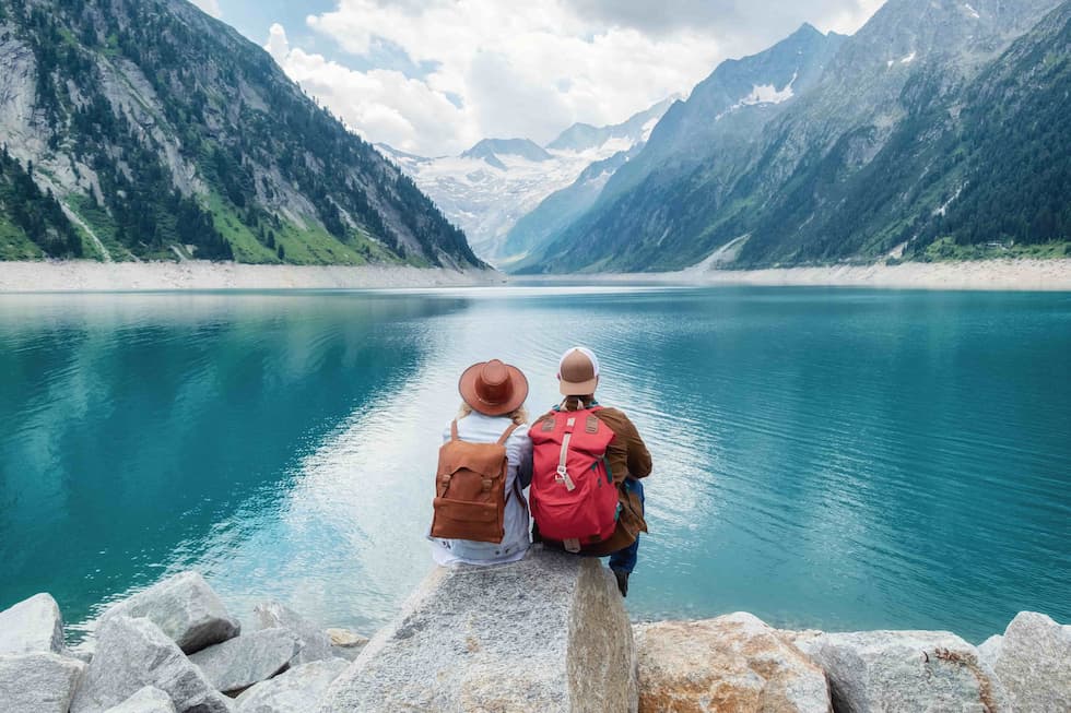 Two nurses sitting on a rock looking over a lake staying healthy as travel nurses
