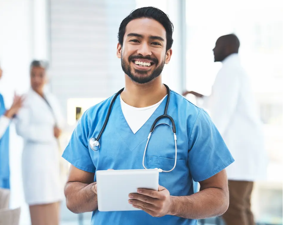Nurse smiling in a hospital while holding a tablet
