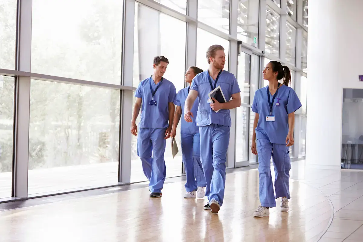 Group of healthcare workers walking in a hospital lobby