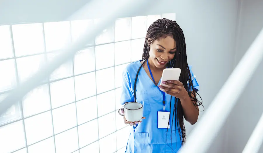 Nurse using her phone to download must-have apps for travel nurses while on a break